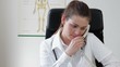 Doctor talking on landline phone and working on tablet computer