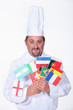 a chief cook holding a lot of foreign flags