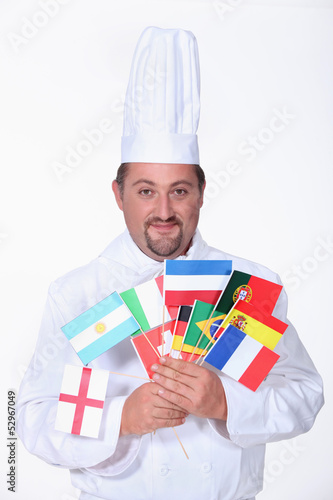 Photo: a chief cook holding a lot of foreign flags a chief cook holding a lot of foreign flags