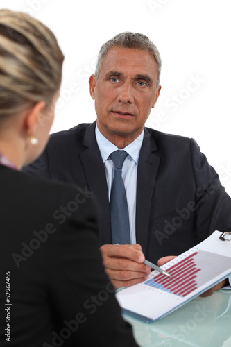 Photo: Boss explaining financial results to female employee Boss explaining financial results to female employee