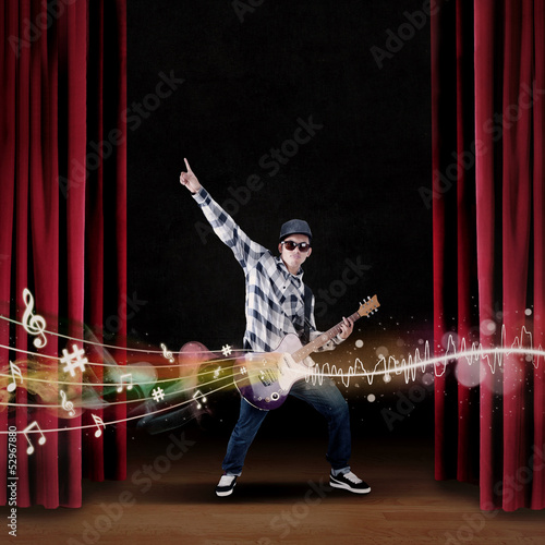 Photo: Artist play guitar on stage with musical notes Artist play guitar on stage with musical notes