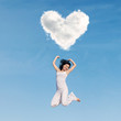 Asian woman jumping under heart cloud