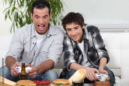 Photo: father and son playing to video games father and son playing to video games