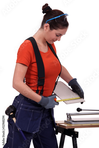 Photo: Woman cutting a tile Woman cutting a tile