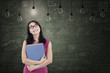 Beautiful female student under light bulbs in class