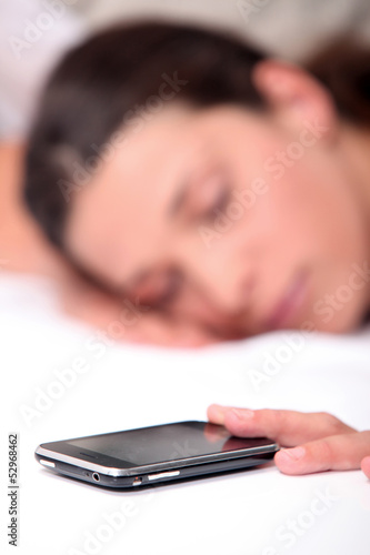Photo: Woman asleep next to mobile telephone Woman asleep next to mobile telephone
