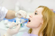 dentist holding a syringe and anesthetizing his patient