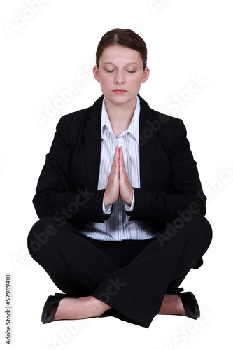 Photo: Young businesswoman meditating Young businesswoman meditating