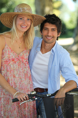 Photo: Young couple taking a bike ride Young couple taking a bike ride