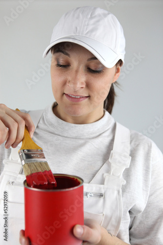 Photo: female painter with red tin of paint and brush female painter with red tin of paint and brush