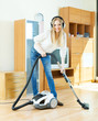  blonde woman in headphones cleaning with vacuum cleaner