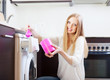 Happy blonde woman putting whitener