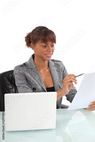 Photo: Smiling businesswoman reading a document Smiling businesswoman reading a document