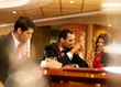 Photo: Happy young people sitting with drinks behind table Happy young people sitting with drinks behind table