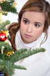 Photo: Young woman looking at Christmas ornaments Young woman looking at Christmas ornaments