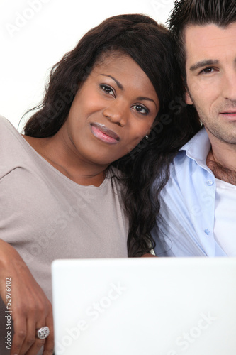 Photo: Mixed couple with laptop Mixed couple with laptop