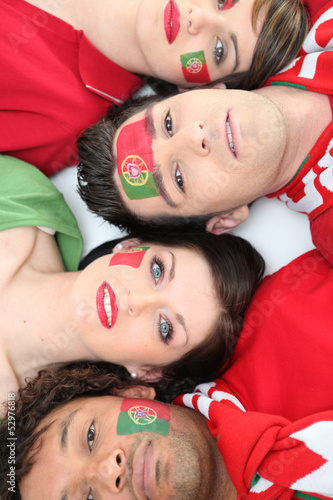 Photo: Four Portuguese soccer fans laying down together Four Portuguese soccer fans laying down together