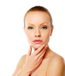 Young woman touching her face isolated on white background