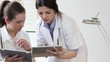 Two female doctors with tablet computers, tracking shot