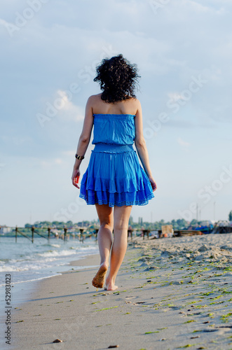 Photo: Barefoot woman walking on a beach Barefoot woman walking on a beach