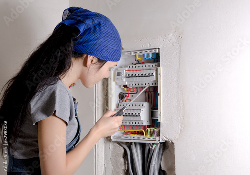 Photo: Woman looking at an open electrical box Woman looking at an open electrical box