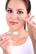 Young woman putting contact lens in her eye close up