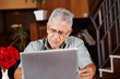 Senior im Hotel mit Tablet Computer
