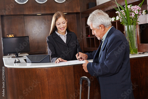 Photo: Gast unterschreibt Formular im Hotel Gast unterschreibt Formular im Hotel