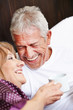 Zwei Senioren lachen im Bett