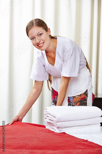 Photo: Zimmermädchen macht Bett in Hotelzimmer Zimmermädchen macht Bett in Hotelzimmer