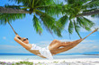 Foto: view of nice young lady swinging in hummock on tropical beach view of nice young lady swinging in hummock on tropical beach