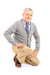 Foto: Smiling mature man kneeling Smiling mature man kneeling