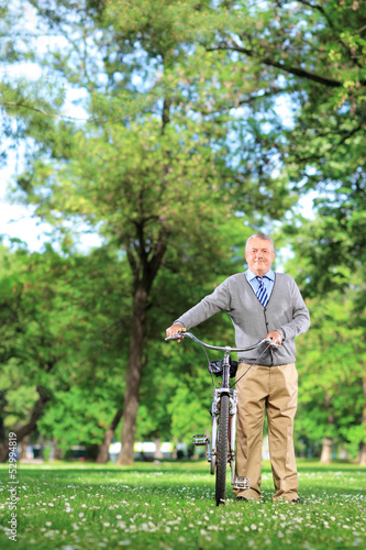 Photo: Mature man pushing a bicycle Mature man pushing a bicycle