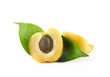 Half of apricot with a pit and leafs on a white background