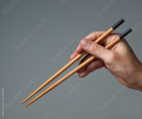 Photo: Male hand with chopsticks. Male hand with chopsticks.