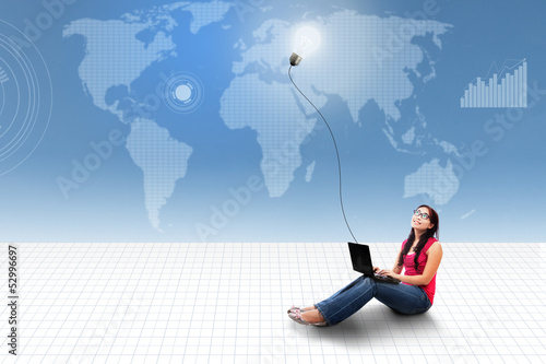 Photo: Asian female using laptop on world map Asian female using laptop on world map