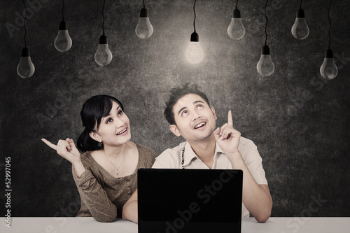 Photo: Couple looking at light bulb on chalkboard Couple looking at light bulb on chalkboard