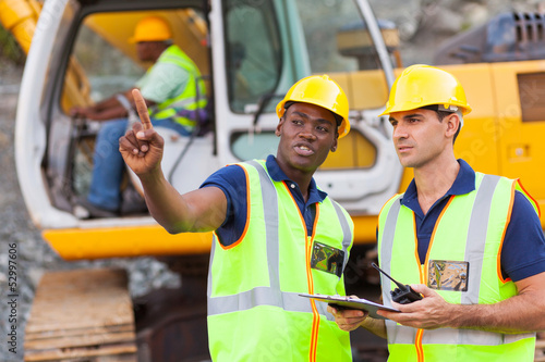 Photo: co-workers talking at construction site co-workers talking at construction site