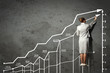 Woman standing on ladder drawing on wall