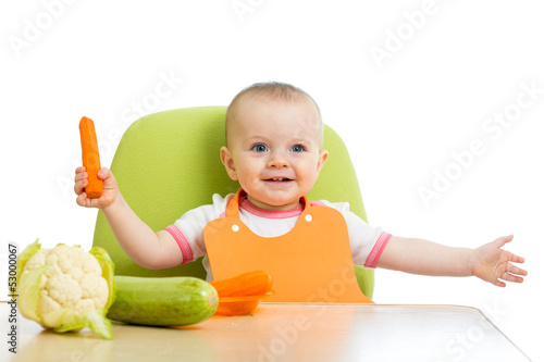 Photo: happy baby girl eating vegetables happy baby girl eating vegetables