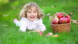 Happy child with red apples in autumn park