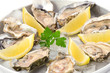 Plate with oysters and lemon on ice closeup.Fresh seafood.