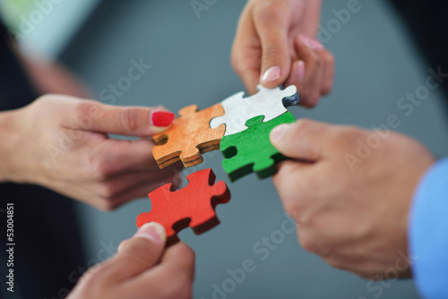 Photo: Group of business people assembling jigsaw puzzle Group of business people assembling jigsaw puzzle
