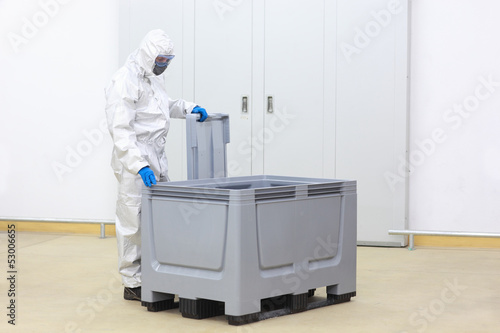 Photo: safety - technician checking contents of plastic container safety - technician checking contents of plastic container
