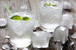 Glass of water with ice cubes on vintage wooden planks
