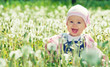 happy baby girl on  meadow with white flowers  on the nature