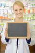 Photo: Freundliche Apothekerin hält leere Tafel Freundliche Apothekerin hält leere Tafel