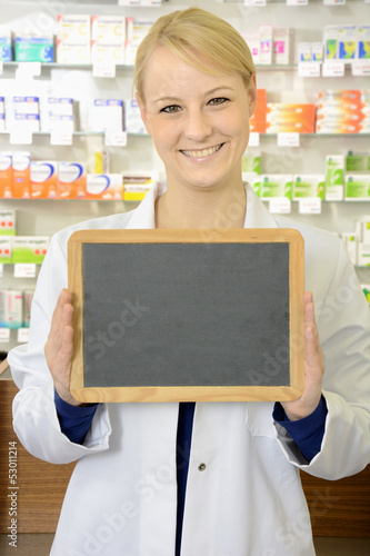 Photo: Freundliche Apothekerin hält leere Tafel Freundliche Apothekerin hält leere Tafel
