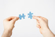 two hands trying to connect puzzle pieces