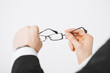 man hands holding eyeglasses